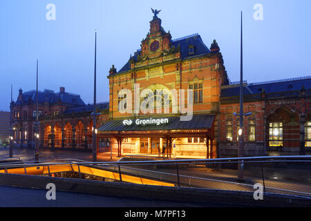 Groningen, Pays-Bas - 31 décembre 2016 : Les gens en face de la gare en soirée. L'actuel bâtiment de la gare a été conçue par Gosscha Izaak Banque D'Images