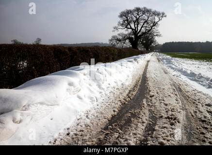 Une route de campagne en hiver avec la neige, Warwickshire, UK Banque D'Images