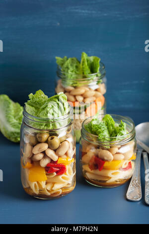 Salade de pâtes et de couscous végétalien dans des pots Mason avec haricots Légumes Banque D'Images