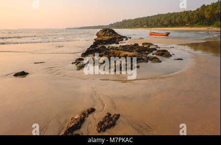 Chera rock en plein milieu d'une plage de sable et donnant sur la mer d'Oman bateau en bois au coucher du soleil près de Thottada village, New Delhi, Ind Banque D'Images