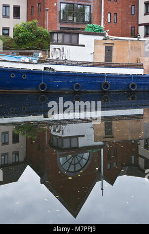 La réflexion d'un vieux bateau en bois amarré le long des rives du canal d'Exeter sur Exe Valley Way juste au sud d'Exeter, Devon, Angleterre Banque D'Images