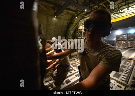 L'AÉRODROME DE BAGRAM (Afghanistan) - Le Sergent de l'US Air Force. Michael Gibbons, originaire de Grand Rapids, Michigan, et actuellement affecté à la 455 e Escadron expéditionnaire port aérien en collaboration avec d'autres aviateurs pousser une palette le long des rouleaux d'un C-130 Hercules J Super à Bagram Airfield, Afghanistan, le 14 juin 2014. Aviateurs affectés à 455 PAE a rejoint avec les entrepreneurs en boxe, la palettisation et le chargement de plus de 18 000 livres de nourriture pour livraison à base d'Jalabad dans trois heures d'être retiré du congélateur. Gibbons est déployé à partir de la Base des forces aériennes Altus, Okla. (U.S. Air Force p Banque D'Images