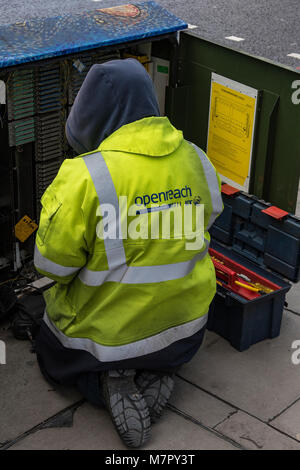 Une large bande bt openreach british telecom téléphone ingénieur travaillant dans un cabinet d'échange portant une veste haute visibilité. Ingénieur ouvrier téléphones. Banque D'Images