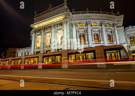 Low angle statique photo de nuit de tram arrivant à l'arrêt en face de Burgtheater de Vienne Banque D'Images