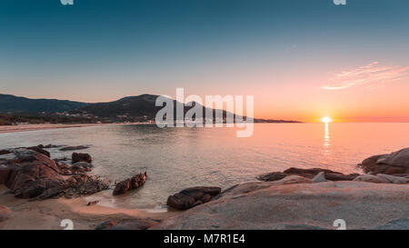 Coucher de soleil sur les affleurements rocheux et plage de sable à Algajola en Balagne Corse Banque D'Images