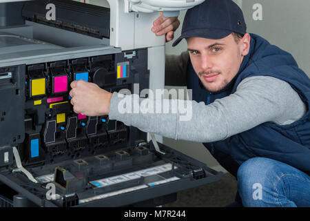 L'homme en remplacement des cartouches d'encre photocopieur Banque D'Images