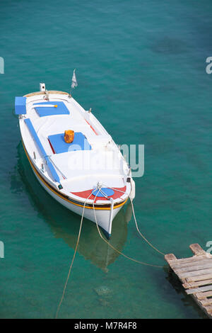 Un bateau amarré dans un petit village grec Mandrakia, île de Milos, Cyclades, Grèce. Banque D'Images