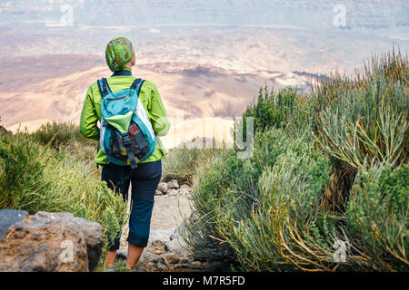 Une jeune femme marche dans les montagnes et admire une vue magnifique Banque D'Images