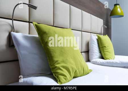 Oreiller vert, les lampes de lecture et tête de lit en cuir dans la chambre à coucher moderne Banque D'Images