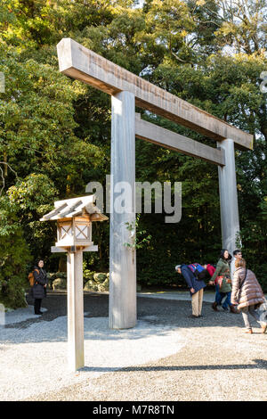 Le Japon, l'Ise, Ise-jingu, sanctuaire Geku extérieur. Vou de torii à l'entrée du sanctuaire. Les gens de passage, certains s'inclinant d'abord. Banque D'Images