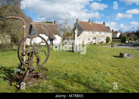 Dans de charmants cottages au toit de chaume village Martin dans le Hampshire, au Royaume-Uni, avec le vieux village sur le livre vert de la pompe à eau Banque D'Images