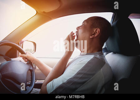 Le bâillement Sleepy man driving car dans la circulation après de longues heures de route. L'homme s'endormir dans la voiture. Banque D'Images