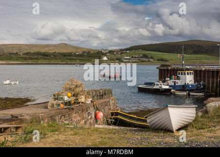 Aultbea, ÉCOSSE - 9 juin 2012 : Port de Aultbea avec pier et quelques chaloupes et bateaux de pêche. Casiers à homard à terre. Les collines boisées à l'arrière. Gr Banque D'Images