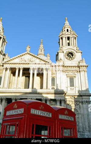 La façade ouest de la cathédrale St.Pauls rouge avec des cabines téléphoniques en premier plan, Ville de London England UK Banque D'Images