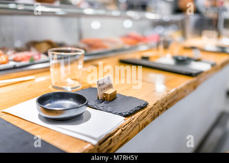 Restaurant japonais signer dans un style traditionnel, intérieur en bois asiatique sushi bar, menu, bol, verre, serviette vide réglage gros plan personne Banque D'Images