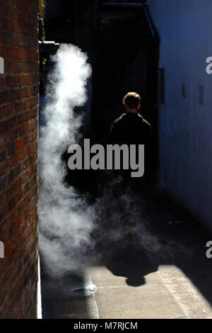 Figure marchant dans une ruelle sombre misty. Banque D'Images