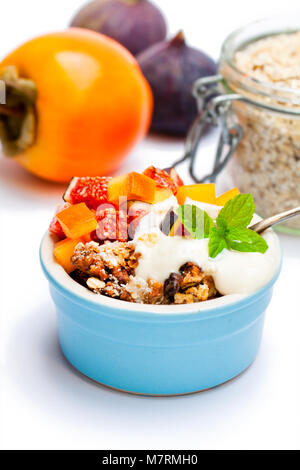 Crumble de fruits avec des flocons d'avoine et kaki et fig isolated on white Banque D'Images