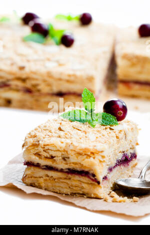 Gâteau Napoléon avec la canneberge et la menthe sur fond blanc Banque D'Images