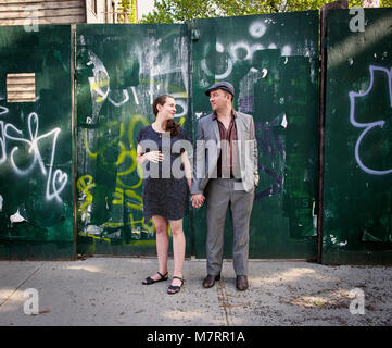 A pregnant couple standing on a street à Williamsburg, Brooklyn. Banque D'Images