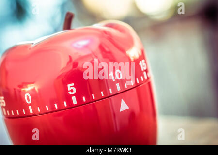 10 Minutes - Macro d'un sablier de cuisine rouge en forme de pomme sur une table Banque D'Images