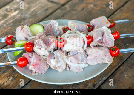 Brochettes marinées shish kebab sur se trouve sur une plaque sur une table en bois avant la cuisson Banque D'Images