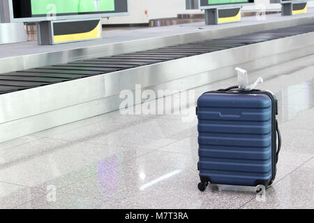 Oublié une valise perdue dans le hall de l'aéroport. Un cas se trouve sur roues à l'assurance transporteur courroie. Banque D'Images