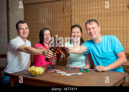 Cheerful friends boire de la bière à l'intérieur jeu de carte Banque D'Images