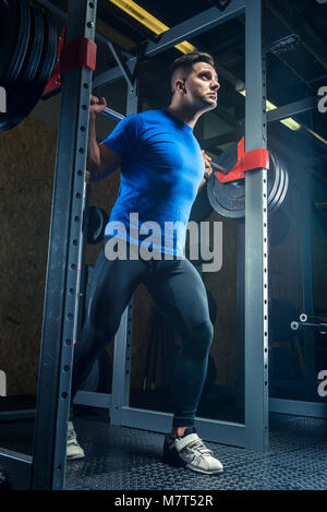 Portrait d'un bodybuilder avec une tige dans la salle de sport au cours de la formation, vue de dessous Banque D'Images
