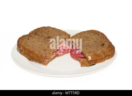 Deux sandwiches de pain à grains entiers avec des tranches de saucisson sur une plaque blanche Banque D'Images