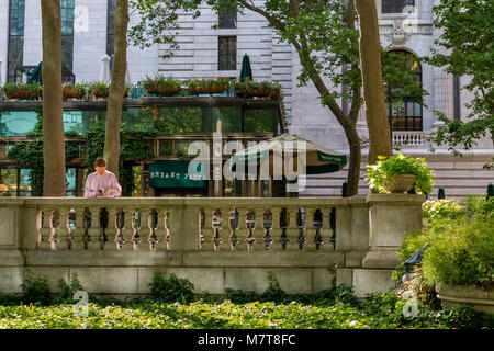 Homme regardant son téléphone dans son téléphone à Bryant Park , Manhattan , New York Banque D'Images