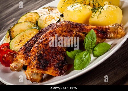 Cuisse de poulet au barbecue avec des pommes de terre et légumes Banque D'Images