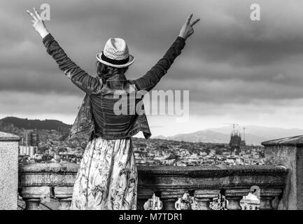 Soirée parfaite avec vue magnifique. Vus de derrière, voyageur élégant femme en robe et chapeau de paille dans l'avant du paysage urbain de Barcelone, Espagne Banque D'Images