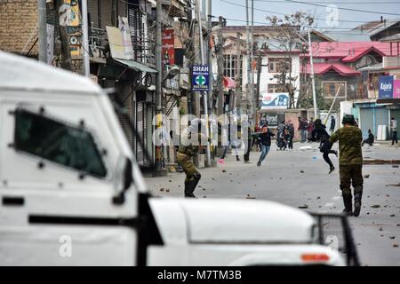 Srinagar, au Cachemire. 12 mars, 2018. Les manifestants du Cachemire indien en conflit avec la police lors d'une manifestation à Srinagar, Cachemire sous administration indienne. Au milieu des affrontements, des milliers de personnes ont participé dans les derniers sacrements de l'Eesa Fazili, un étudiant en ingénierie tourné militant. Jésus n'a été tué dans une fusillade brève le long avec deux associés dans Hakoora Kashmirâ sud du village, district d'Anantnag plus tôt aujourd'hui. Credit : ZUMA Press, Inc./Alamy Live News Banque D'Images