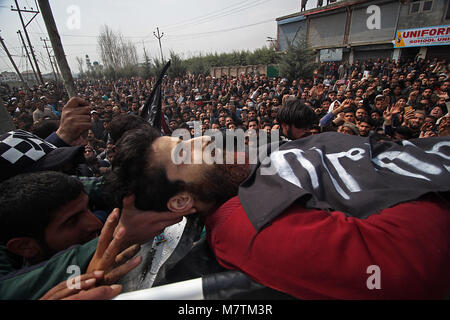 Le cachemire. 12 mars, 2018. Les gens portent le corps d'un militant local Eesa Fazili Soura en matière de Srinagar, la capitale d'été du Cachemire sous contrôle indien le 12 mars 2018.Des milliers de personnes ont participé à la prière funéraire de militant tué Fazili à Ahmadnagar, dans la banlieue de Srinagar. Fazili un étudiant en ingénierie a été tué dans une fusillade avec ses deux associés dans Hakura village de South d'Anantnag du Cachemire. La police a déclaré . Banque D'Images