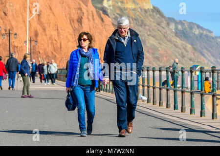 La ville de Sidmouth, Devon, UK. 13 mars 2018. Météo britannique. Les visiteurs et les résidents bénéficiant d'une promenade le long du front de mer de la station balnéaire de Sidmouth dans le Devon par une chaude après-midi de printemps ensoleillé. Crédit photo : Graham Hunt/Alamy Live News. Banque D'Images