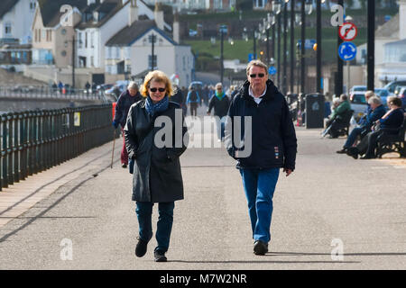 La ville de Sidmouth, Devon, UK. 13 mars 2018. Météo britannique. Les visiteurs et les résidents bénéficiant d'une promenade le long du front de mer de la station balnéaire de Sidmouth dans le Devon par une chaude après-midi de printemps ensoleillé. Crédit photo : Graham Hunt/Alamy Live News. Banque D'Images