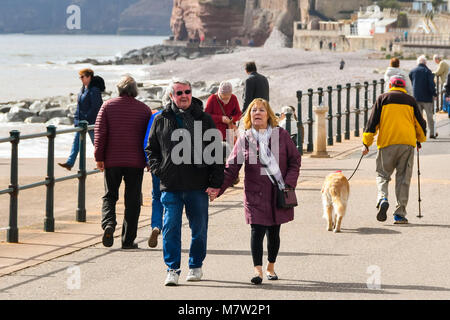 La ville de Sidmouth, Devon, UK. 13 mars 2018. Météo britannique. Les visiteurs et les résidents bénéficiant d'une promenade le long du front de mer de la station balnéaire de Sidmouth dans le Devon par une chaude après-midi de printemps ensoleillé. Crédit photo : Graham Hunt/Alamy Live News. Banque D'Images