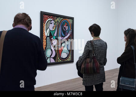 Londres, Royaume-Uni. 13 mars 2018. Les membres du public vue 'Girl devant un miroir (Jeune fille devant un miroir)', 1932, par Pablo Picasso, à l'affiche au 'Picasso 1932 - L'amour, la gloire, la tragédie, la Tate Modern de la toute première exposition solo de l'œuvre de Pablo Picasso. Plus de 100 peintures, sculptures et oeuvres sur papier portant sur l'année 1932, une période charnière de la vie de Picasso, sont sur l'affichage 8 mars au 9 septembre 2018, dans l'un des spectacles les plus populaires de l'année à la Tate Modern. Crédit : Stephen Chung / Alamy Live News Banque D'Images