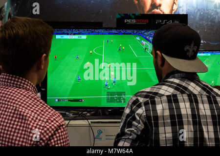 Cologne, Allemagne - 24 août 2017 : deux visiteurs juste jouer le jeu Pro Evolution Soccer sur le stand de la société Konami à Gamescome 2017. Banque D'Images