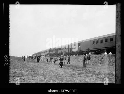 Pendant les troubles palestiniens de 1936, des passagers sont vus en train de passer d'un train déraillé à un train de secours près de Ras el-Ain. Cet événement illustre les difficultés rencontrées par les civils et les efforts déployés pour les aider pendant les troubles. Banque D'Images