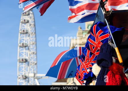 London Eye Millennium Wheel Coca Cola Ferris Wheel à Londres, Royaume-Uni. Avec parapluie drapeau Union Jack et chapeaux sur le stand souvenir. Britannique Banque D'Images