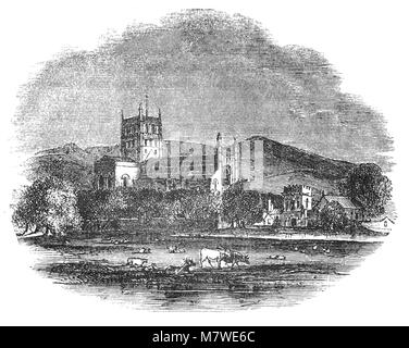 Bovins en face de l'église de l'abbaye de St Mary the Virgin, Tewkesbury, (communément connu sous le nom de Abbaye de Tewkesbury), dans le comté anglais du Gloucestershire, Angleterre est une église paroissiale et un ancien monastère bénédictin. C'est l'un des plus beaux exemples d'architecture Normande en Grande-Bretagne et a probablement, la plus grande tour de passage romane en Europe. Il a été un centre de culte depuis le 7ème siècle, devenant un prieuré dans le 10e. Le bâtiment actuel a été commencé au début du xiie siècle. Banque D'Images