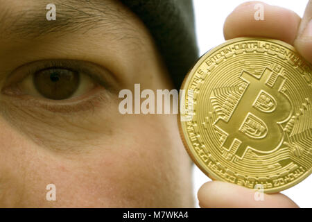 Bitcoin fou amoureux avec une pièce d'or dans votre main , drôle miner avec BTC près du visage Banque D'Images