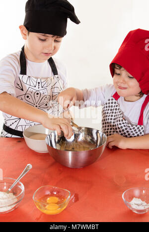 Vêtements mignon petit garçon chef préparer cupcakes Banque D'Images