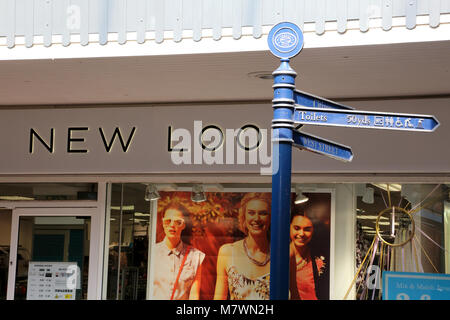 Panneau de métal bleu Nouveau look extérieur store à Leighton Buzzard, Bedfordshire, Royaume-Uni, en pointant sur "toilettes". Signe est obscurcissant le 'K' à New Look. Banque D'Images