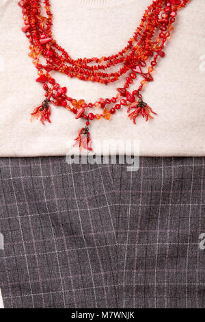 Collier avec petites pierres polies rouge. Portrait close up vue verticale de l'hiver Vêtements et accessoires. Banque D'Images