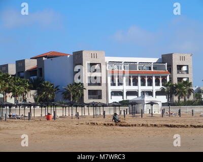 AGADIR, Maroc afrique sur février 2017 : construction de l'hôtel moderne et des parasols sur la plage au bord de mer de la ville de voyage avec des paumes en beauté à l'extérieur p Banque D'Images