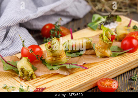 Mini rouleaux de courgette sur un fond de bois. La vie encore. Rustique. Banque D'Images