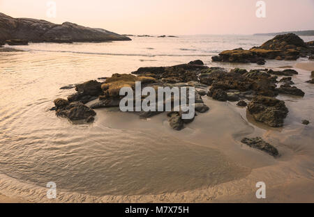 Chera rock en plein milieu d'une plage de sable et donnant sur la mer d'Oman bateau en bois au coucher du soleil près de Thottada village, New Delhi, Ind Banque D'Images