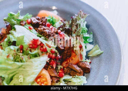 Foie et salade de grenades sur une plaque gris in cafe Banque D'Images